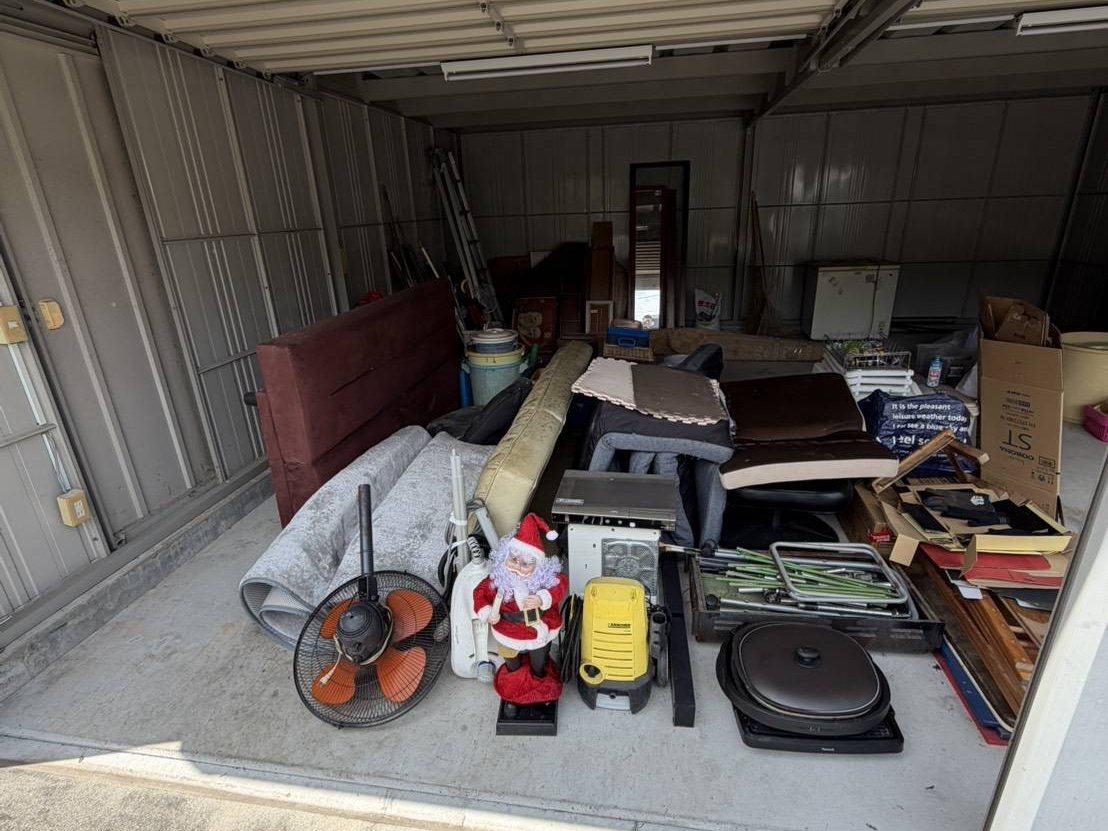 片付け前の倉庫：家具・家電・段ボールが積まれた状態
